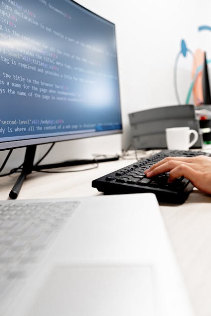 The image displays a close-up view of a computer screen showing lines of code with syntax highlighting in various colors, including pink, blue, green, and white, set against a dark background. The cod
